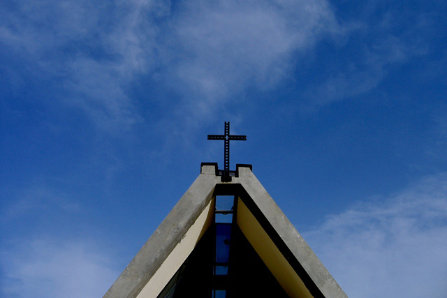 Spiret på en kirke med en kraftig klar blå himmel i bakgrunnen. Foto.